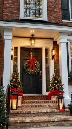 christmas wreaths on the front steps of a house