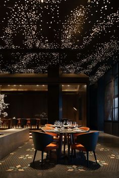 a dining room filled with lots of tables and chairs next to a wall covered in lights