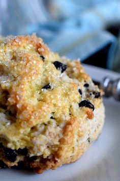 a close up of a muffin on a plate with a fork in the background