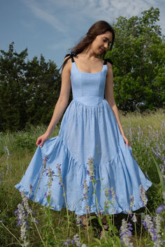 A truly special dress.  With rich black ribbon tie straps, a corset bodice, and sweeping ruffle hem the Mirabelle Dress is dramatic, romantic beauty at its best and one of our most popular styles.  Made in a lightweight blue gingham linen with a sateen finish that gives the linen a subtle dressy luster. A showstopper of a dress made for special moments, celebrations, or romantic getaways. Affordable Cotton Princess Dress, Twirl Dress For Women, Cheap Cotton Dress With Bow, Cheap Cotton Dress With Ruffles, Cheap Cotton Ruffle Dress With Ruffle Hem, Affordable Cotton Ruffle Hem Dress, Romantic Dresses Aesthetic, Ruffle Detail Dress, Gingham Bridesmaids Dresses