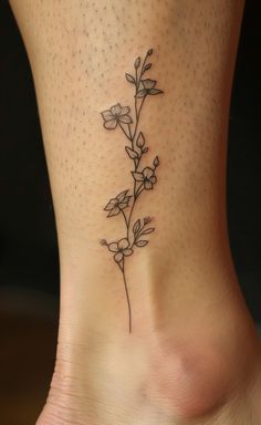 a small flower tattoo on the side of a woman's foot, with dots in the background