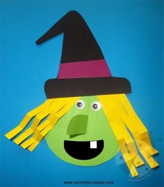 a paper cut out of a witch with yellow hair and black hat on it's head