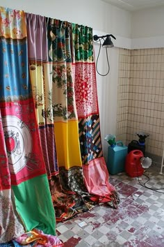 a bathroom with many different colored curtains hanging on the wall