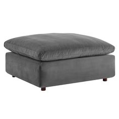 a grey ottoman with wooden legs and a cushion on the bottom, in front of a white background