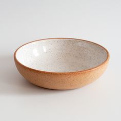 a white and brown bowl sitting on top of a table