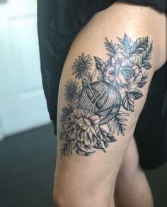 a woman's thigh with flowers and leaves on her leg, in black and white