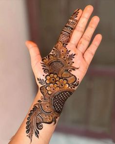 a woman's hand with henna tattoos on it