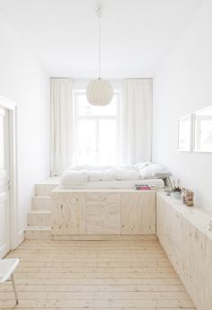 an image of a bedroom with white walls and wood flooring on the bottom level