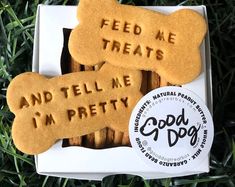 three dog treats in a box with words written on them and a sticker that says feed me treats and tell me i'm'm pretty