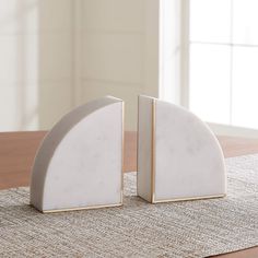 two white marble bookends sitting on top of a table