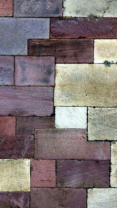 a close up of a brick wall with different colored bricks on it's sides