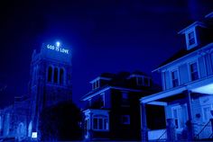 a church tower lit up at night with the word god is love written on it