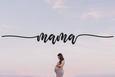 a pregnant woman standing under the word mama