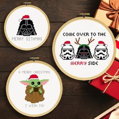 three cross stitch christmas ornaments with star wars characters on them, one has a santa hat and the other is a baby yoda