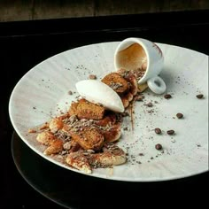 a white plate topped with lots of food on top of a wooden table next to a cup