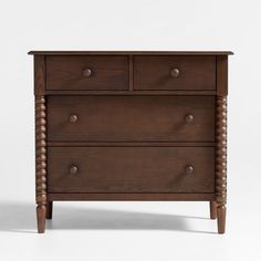 a wooden dresser with three drawers and two knobs on the front, against a white background