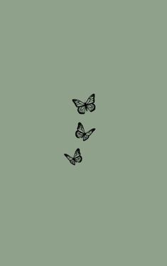 three butterflies flying in the sky on a green background with space for text or image