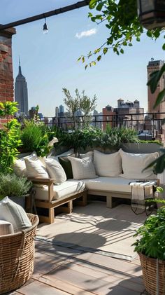 an outdoor patio with lots of plants and couches on the roof top deck, surrounded by greenery