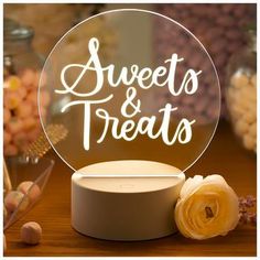 a round glass sign that says sweets and treats on it next to some candies