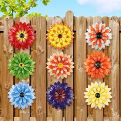 the colorful flowers are on the wooden fence