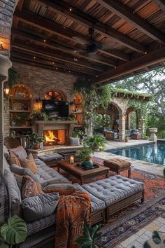 an outdoor living area with couches, tables and a pool in the back ground