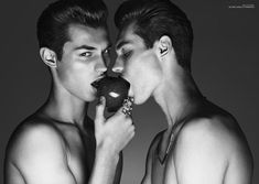 two young men are eating an apple together