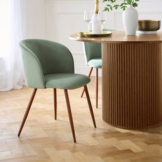 two chairs sitting at a table with vases on the top and one chair next to it