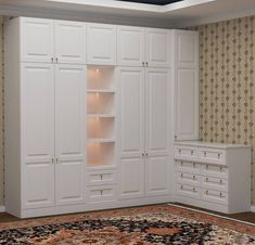 an empty room with white cabinets and rug on the floor in front of wallpapered walls