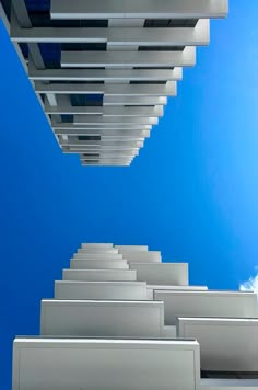 an upward view of some buildings against a blue sky