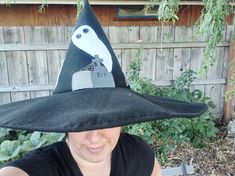 a woman wearing a black hat with a bird on it