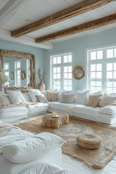 a living room filled with lots of white furniture and pillows on top of a rug