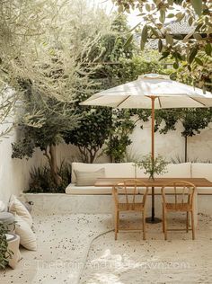 an outdoor dining area with table, chairs and umbrella