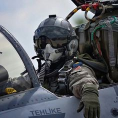 the pilot is sitting in the cockpit of an airplane with his hand on the door handle