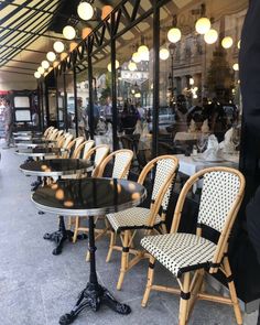 the tables and chairs are lined up on the sidewalk