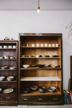 the shelves are filled with plates and bowls