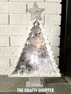 a white christmas tree with silver ornaments on it