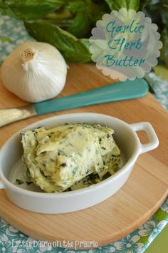 garlic herb butter in a white bowl on a cutting board