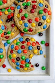 cookies with m & m's and chocolate chips are on a white platter