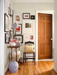 a room with pictures on the wall and a table in front of it next to a door