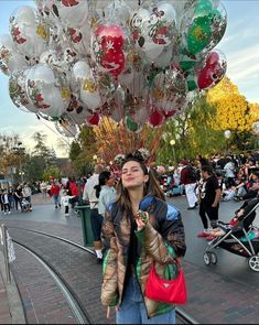 a woman standing in front of a bunch of balloons