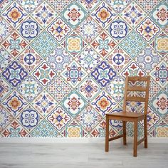 a wooden chair sitting in front of a wall with colorful tiles on it's sides