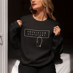 a woman wearing a black sweatshirt with the words,'physician assistant'on it