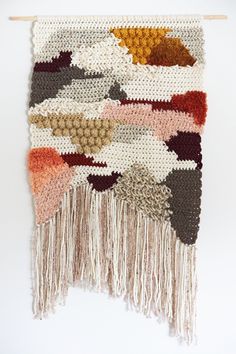 the wall hanging is made up of different colors and sizes, including brown, red, white