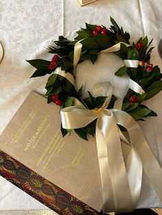 a box with a wreath on top of it next to a ribbon and other items