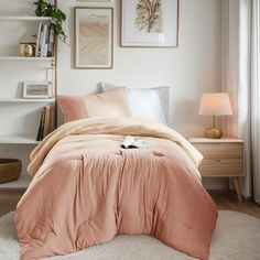 a bedroom with a bed, nightstands and pictures on the wall above it in neutral colors