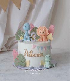 a birthday cake decorated with animals and bunting streamers for an alleen party