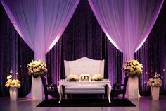 a wedding set up with purple drapes and flowers