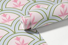 a pink and green wallpaper with flowers on it's back side, next to a roll of white paper