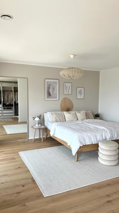 a bed sitting on top of a hard wood floor next to a white rug in a bedroom