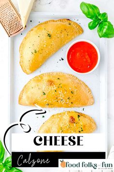 cheese calzones on a white plate with basil leaves and ketchup next to it